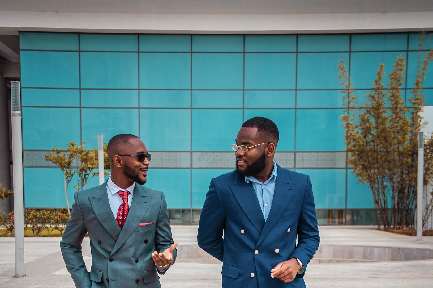 Two businessmen in suits talking outside an office building