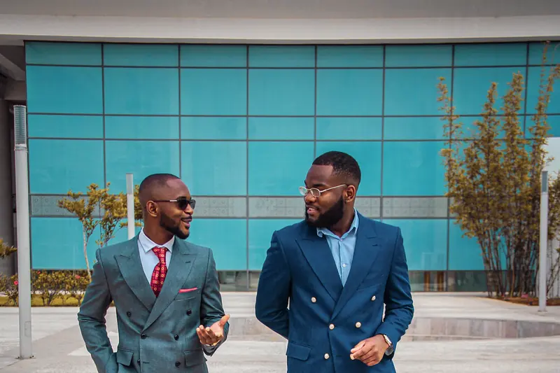 Two businessmen in suits talking outside an office building