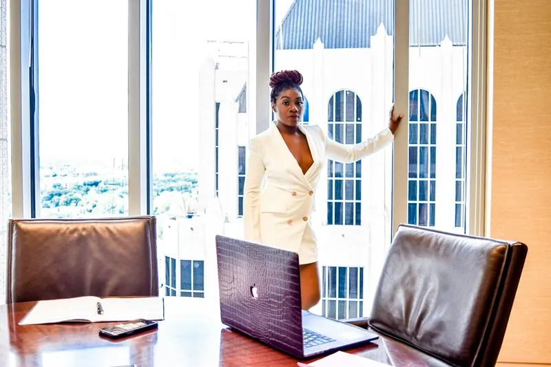 A woman presenting at the head of a boardroom table